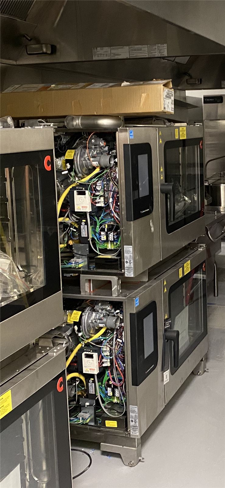 Stacked commercial combi ovens opened up for service